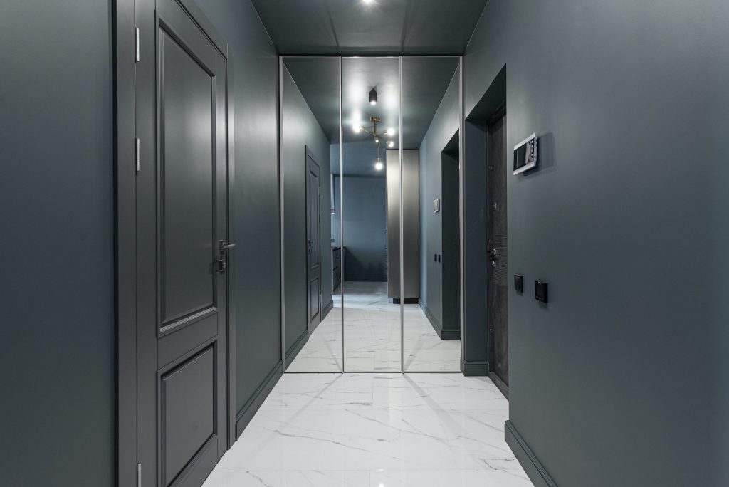Corridor of modern apartment with doors and mirror